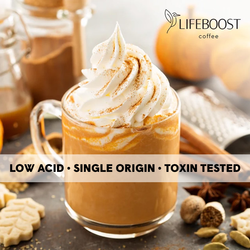 A pumpkin spice latte topped with whipped cream and cinnamon, with the Lifeboost logo and a low acid, single origin badge